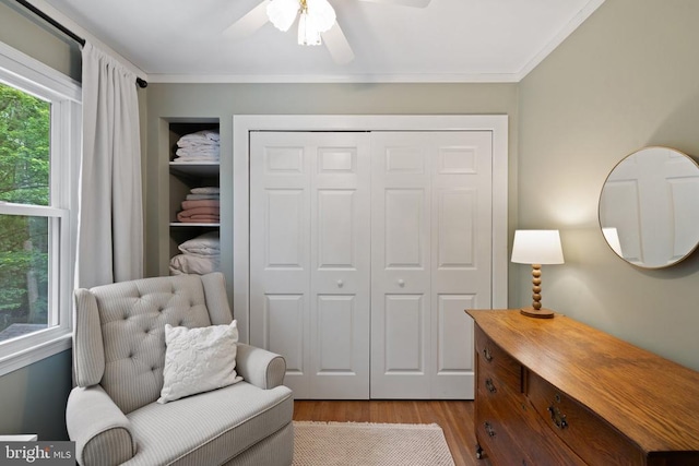  - sitting room with wood finished floors, ornamental molding, and ceiling fan