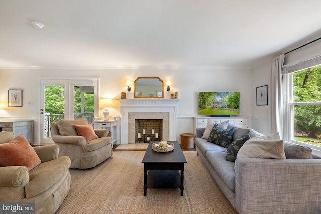  - living area with plenty of natural light, a fireplace with flush hearth, and ornamental molding
