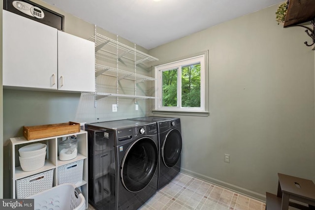 - washroom featuring washing machine and dryer, baseboards, and cabinet space