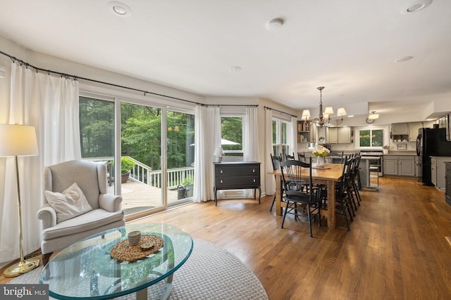  - dining space with a chandelier, wood finished floors, and recessed lighting