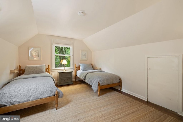  - bedroom with lofted ceiling and baseboards