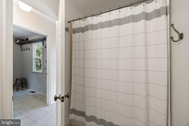  - bathroom featuring ornamental molding, curtained shower, and baseboards