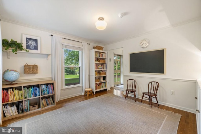  - sitting room with ornamental molding, wood finished floors, and baseboards
