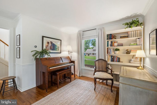  - living area with wood finished floors, crown molding, and baseboards
