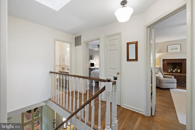 - hallway featuring an upstairs landing, wood finished floors, a skylight, and baseboards