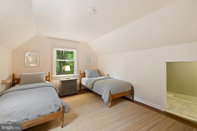 - bedroom featuring vaulted ceiling, baseboards, and light wood-style flooring