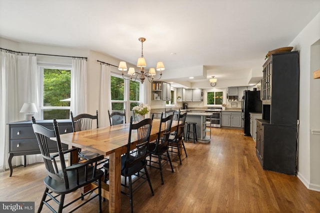  - dining area with a chandelier, wood finished floors, and recessed lighting