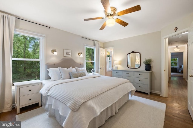  - bedroom with multiple windows, light wood finished floors, ceiling fan, and baseboards