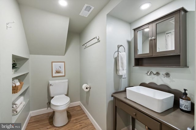  - bathroom with wood finished floors, toilet, baseboards, vanity, and recessed lighting