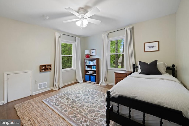  - bedroom featuring multiple windows, wood finished floors, and baseboards