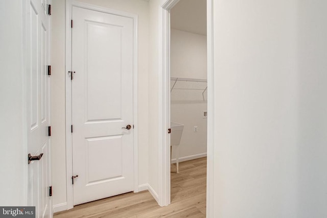 hall featuring baseboards and light wood-style flooring