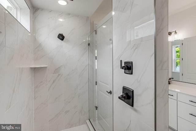 bathroom featuring a marble finish shower and vanity