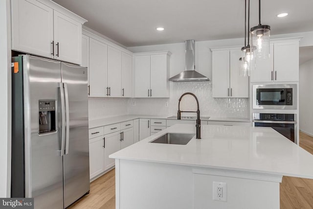 kitchen with wall chimney exhaust hood, white cabinetry, and appliances with stainless steel finishes