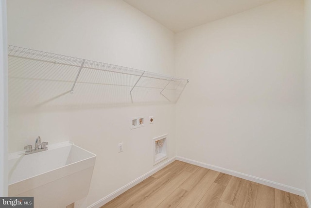 laundry room featuring light wood finished floors, washer hookup, a sink, laundry area, and electric dryer hookup