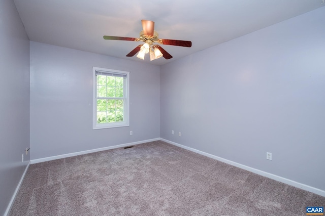 carpeted empty room featuring baseboards and a ceiling fan