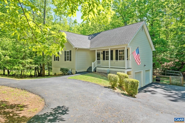 25 Bearwood Dr S, Palmyra, VA 22963 - view of front of house with driveway, roof with shingles, covered porch, an attached garage, and fence