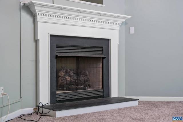 detailed view of a fireplace, carpet flooring, and baseboards