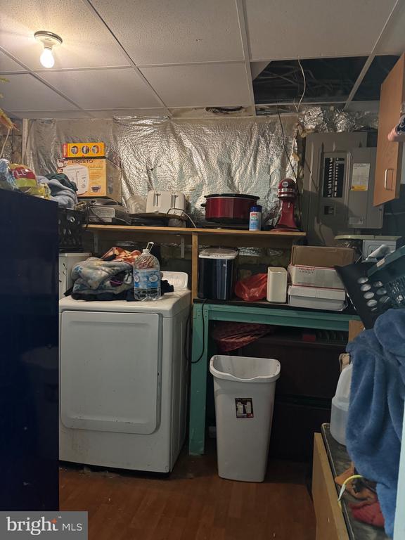 laundry area with washer / dryer, electric panel, and wood finished floors