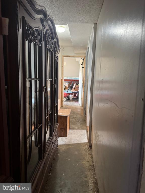 hall featuring unfinished concrete flooring