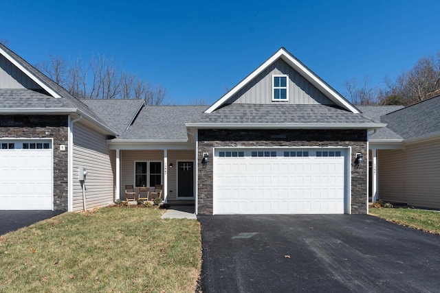 view of front of home featuring a porch, a garage, and a front lawn