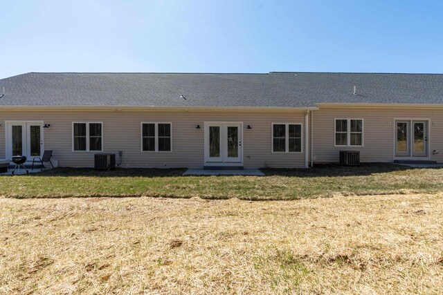 rear view of property featuring french doors, central AC, and a lawn