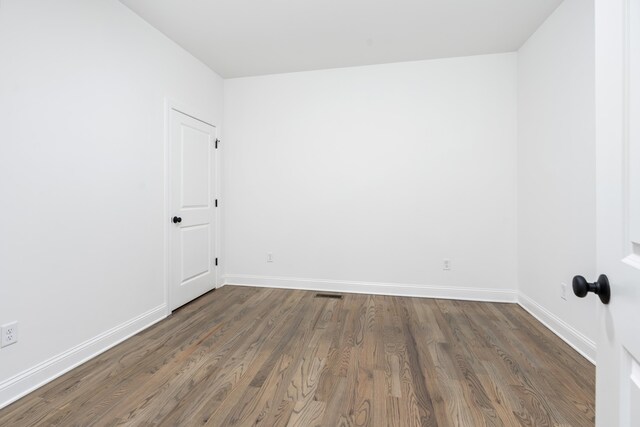 spare room with dark hardwood / wood-style floors