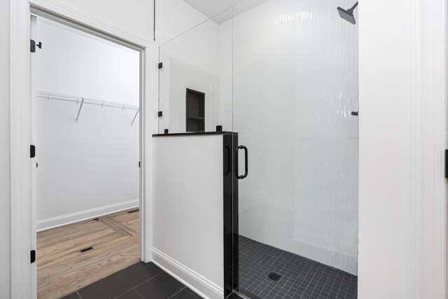 bathroom featuring an enclosed shower and tile patterned floors