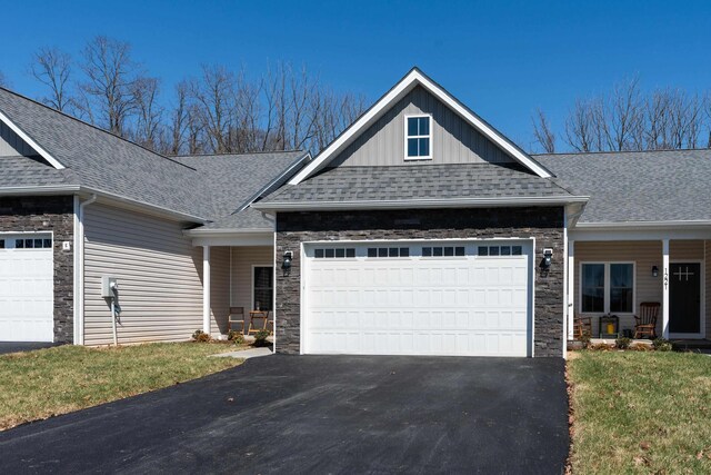 craftsman house featuring a garage and a front lawn