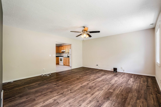 empty room featuring light wood-type flooring, a ceiling fan, baseboards, and a textured ceiling