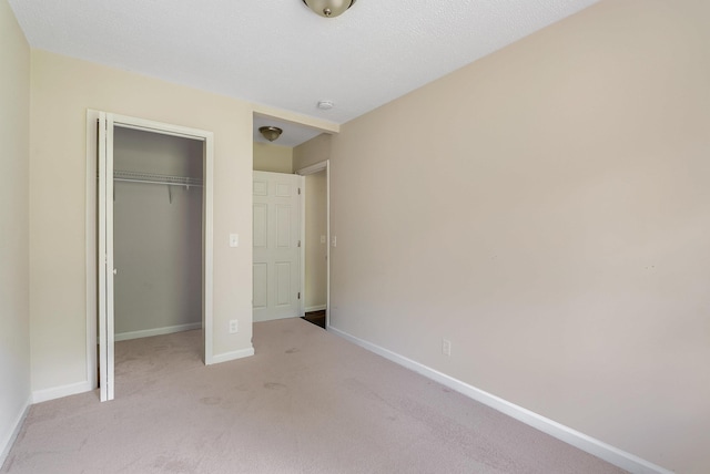 unfurnished bedroom with carpet floors, a closet, and baseboards