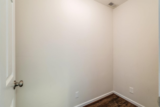 empty room featuring dark wood-style floors and baseboards