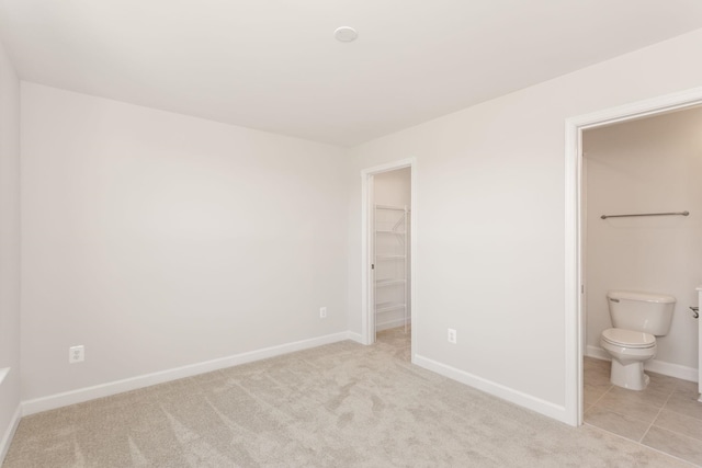 2797 Rutlege Rd Unit 197, Rockingham, VA 22801 - unfurnished bedroom featuring a spacious closet, baseboards, light carpet, and connected bathroom