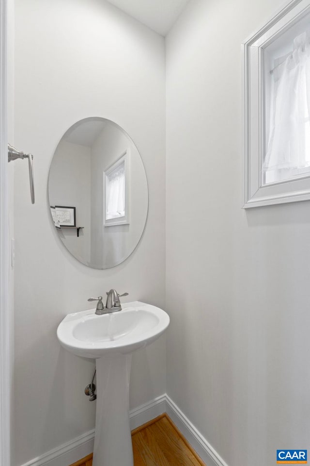 bathroom with baseboards and wood finished floors