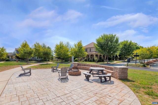 view of community with a fire pit and a lawn