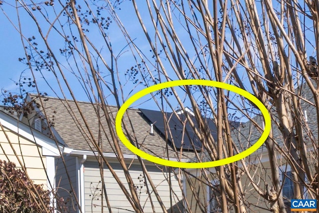exterior details with a shingled roof, gutters, and a downspout