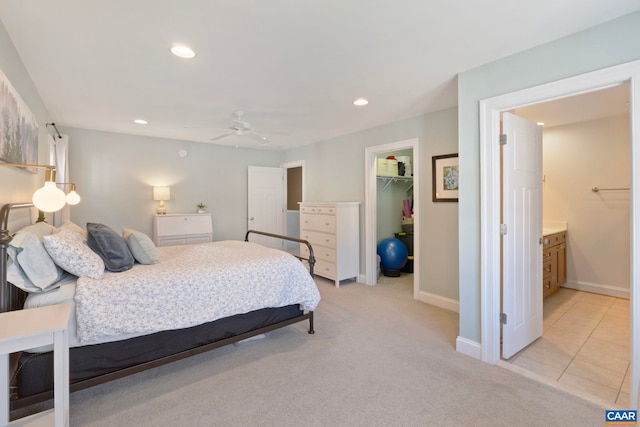 bedroom featuring a spacious closet, recessed lighting, light colored carpet, a closet, and baseboards
