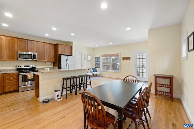 dining room featuring recessed lighting, light wood-style floors, and baseboards