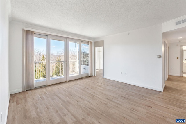 unfurnished living room featuring a textured ceiling, crown molding, light wood-style floors, and baseboards