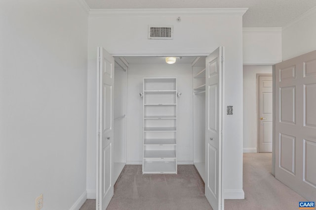 walk in closet featuring light carpet and visible vents