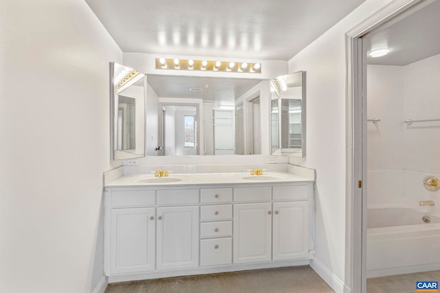bathroom featuring a sink, double vanity, and baseboards