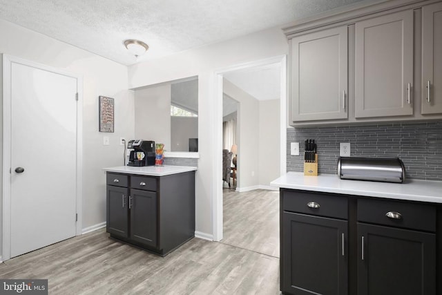 740 Lakeview Pkwy, Locust Grove, VA 22508 - kitchen with gray cabinetry, light countertops, decorative backsplash, light wood-style flooring, and a textured ceiling