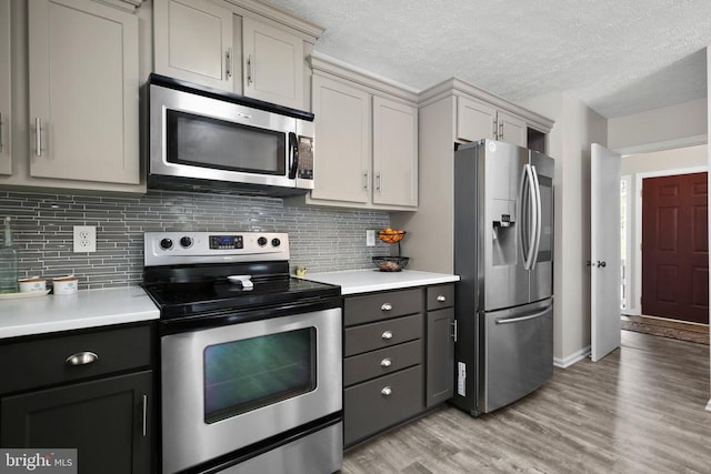 740 Lakeview Pkwy, Locust Grove, VA 22508 - kitchen featuring appliances with stainless steel finishes, light countertops, light wood-type flooring, decorative backsplash, and a textured ceiling