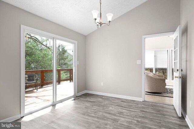 740 Lakeview Pkwy, Locust Grove, VA 22508 - unfurnished dining area with lofted ceiling, a chandelier, wood finished floors, and baseboards