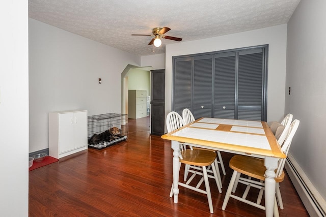 911 Old White Hill Rd, Stuarts Draft, VA 24477 - dining room with a baseboard heating unit, a ceiling fan, wood finished floors, and a textured ceiling