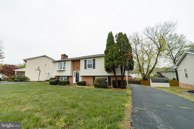 802 Shamrock Dr, Fredericksburg, VA 22407 - split foyer home featuring a chimney, brick siding, a front lawn, and fence