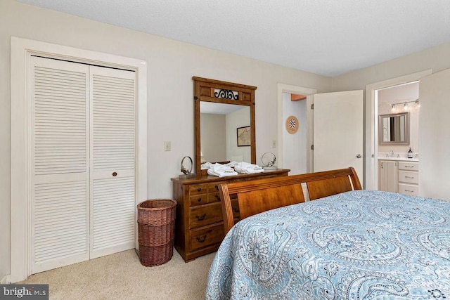 bedroom featuring a textured ceiling, a closet, carpet, and connected bathroom