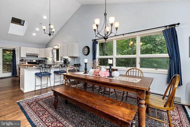 dining space with high vaulted ceiling, a baseboard heating unit, dark wood finished floors, and a notable chandelier