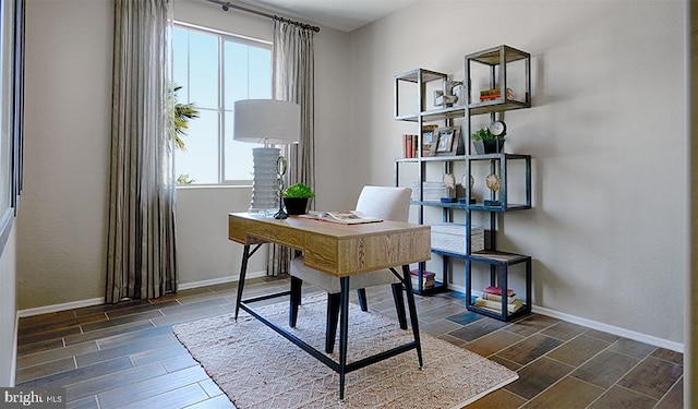 home office with plenty of natural light, wood tiled floors, and baseboards