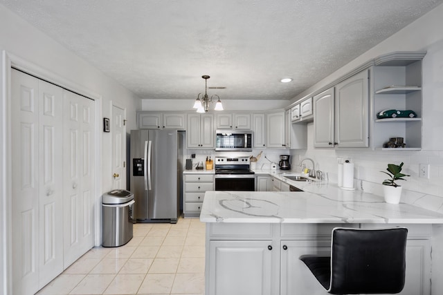 200 Kingsport Rd, Waynesboro, VA 22980 - kitchen featuring a peninsula, stainless steel appliances, light stone countertops, decorative backsplash, and gray cabinetry