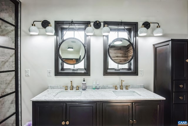 bathroom with double vanity, a healthy amount of sunlight, and a sink